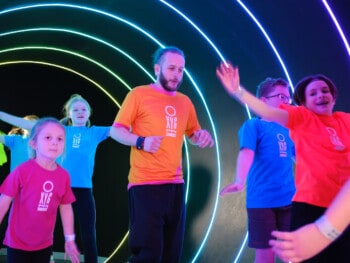 staff and children running through Excite tunnel